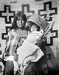 Mujer apache con un niño en su cuna.