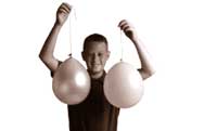 Boy holding two balloons hanging down on a string