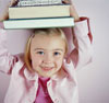 A young girl holding up books